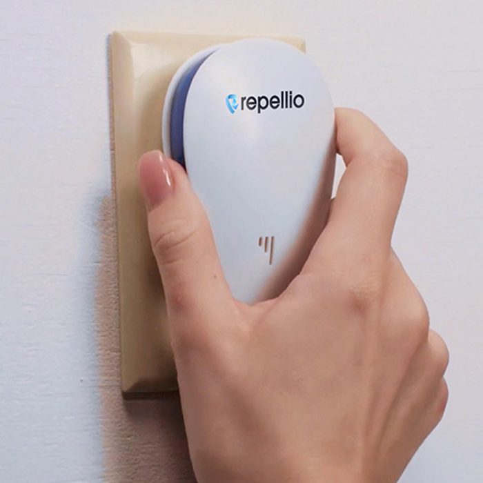 Hand plugging a Repellio device into a wall socket